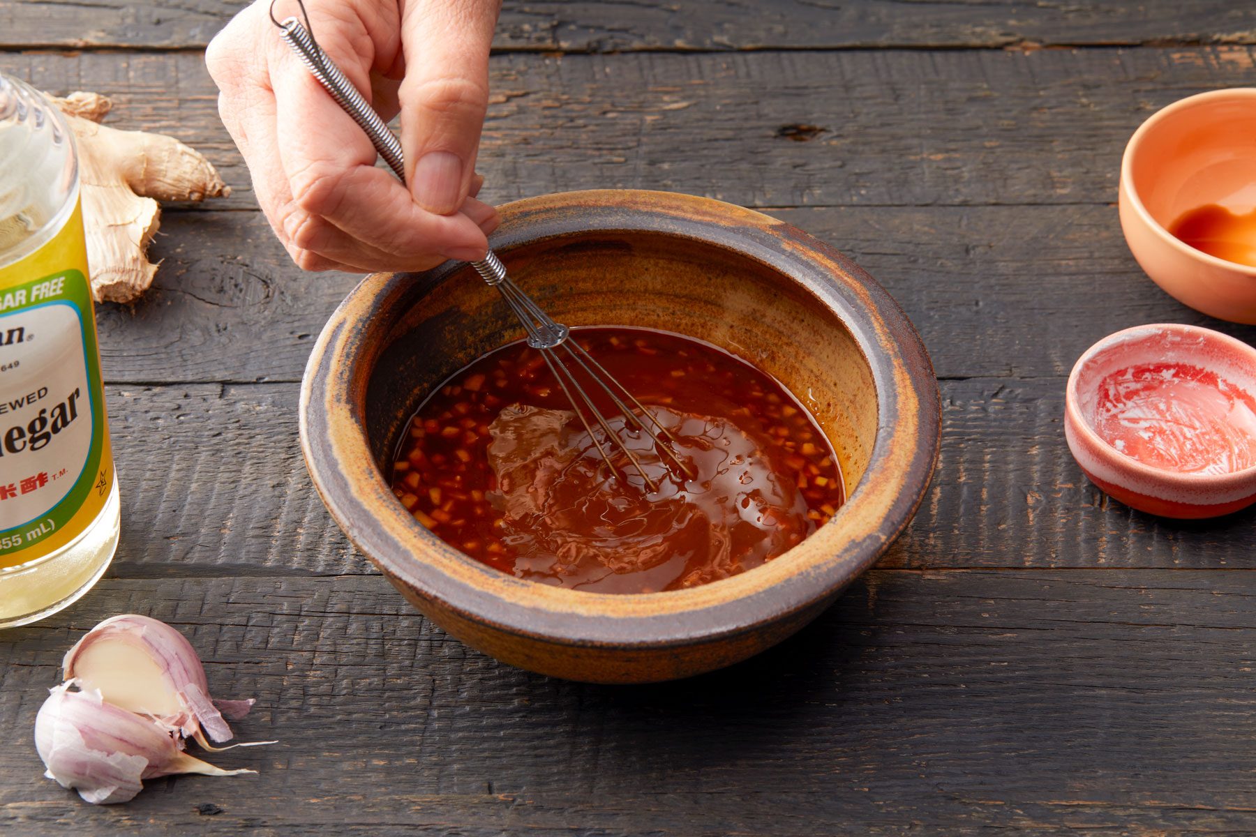 A Hand Whisking a Sauce in a Bowl