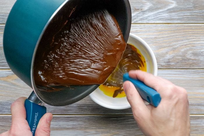 Pouring Chocolate Mix from Saucepan to a White Small Bowl
