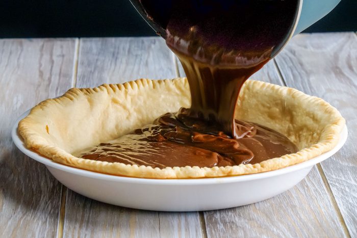 Pouring Chocolate Filling on Pie Crust in Pie Plate