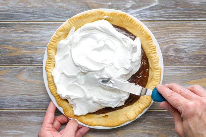 Spreading the Meringue evenly on the Chocolate mix in Pie Crust