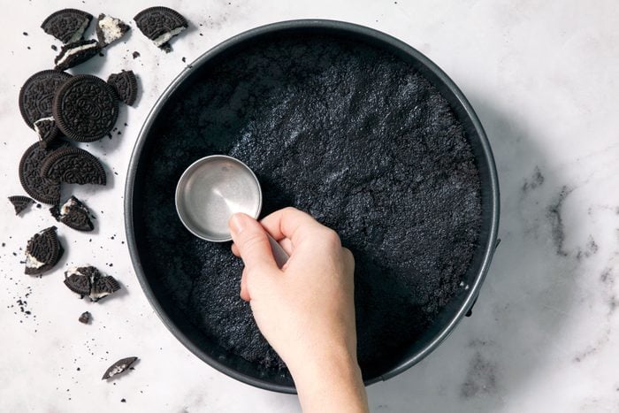 Pressing The Oreo Cookies Mixture Onto The Bottom Of A Greased 9-Inch Springform Pan