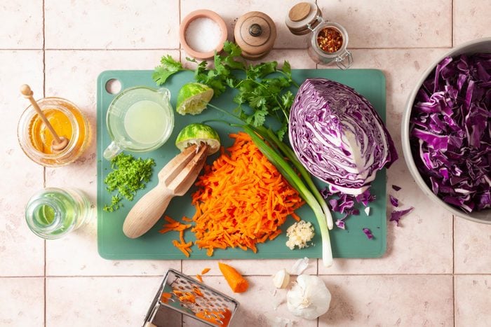 A Cutting Board With Vegetables and a Grater