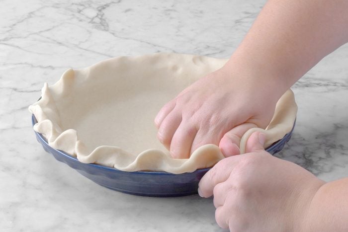A person making the pie crust