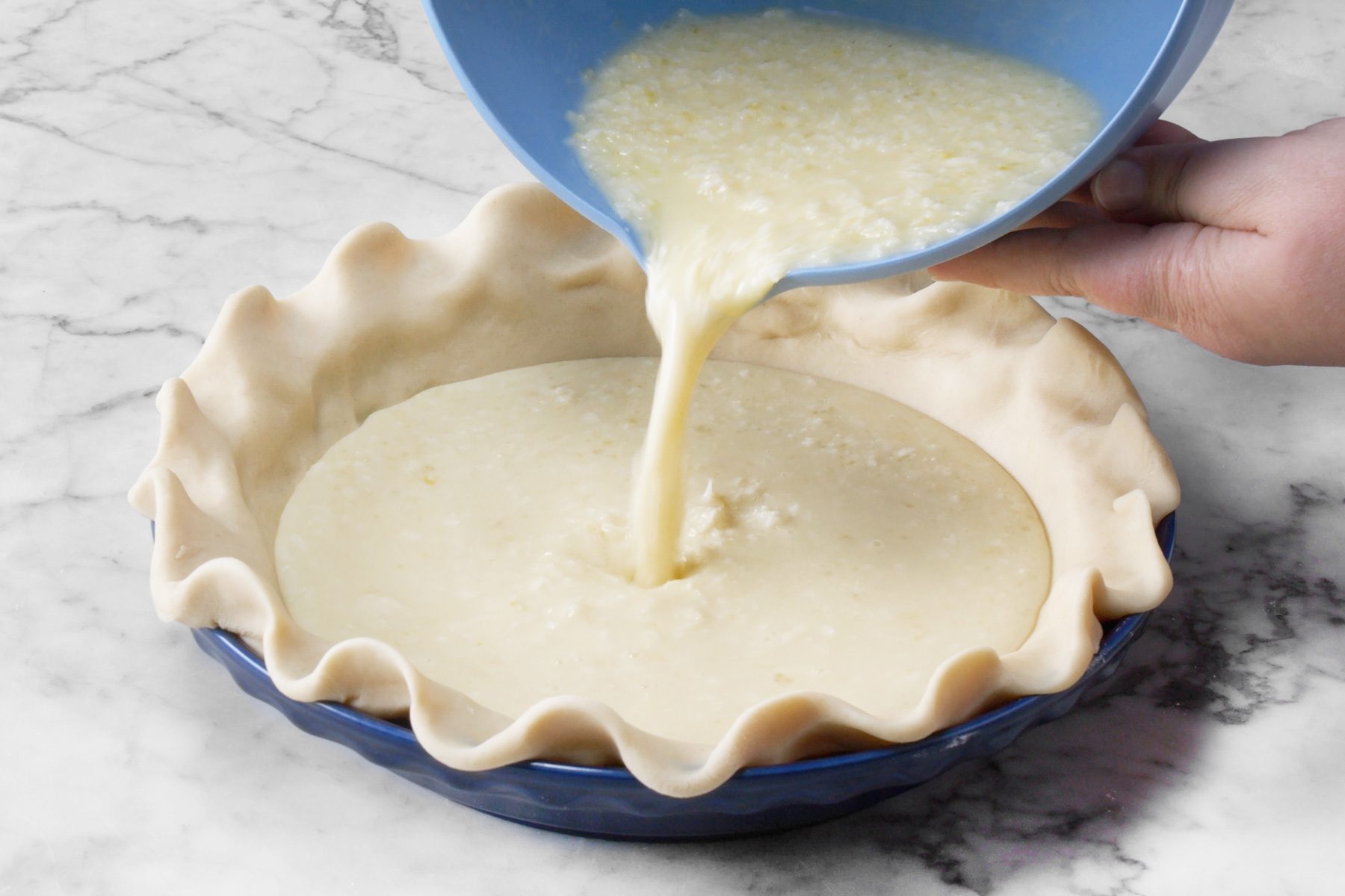 A person pouring the mixture into the pie crust