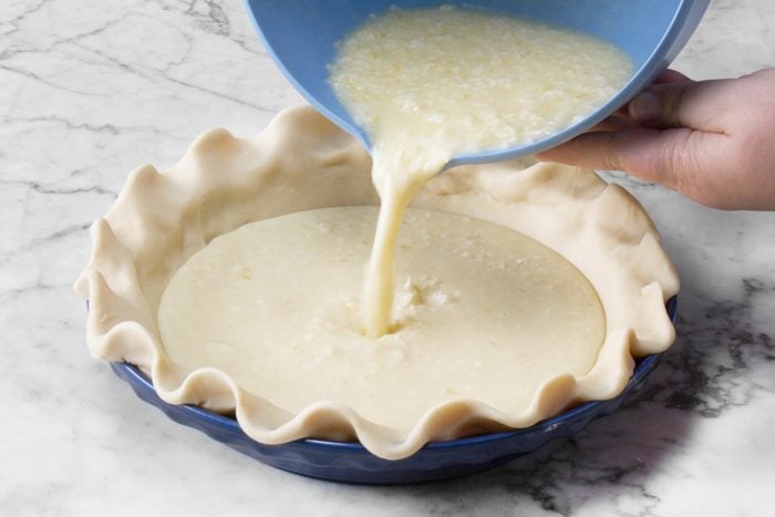 A person pouring the mixture into the pie crust