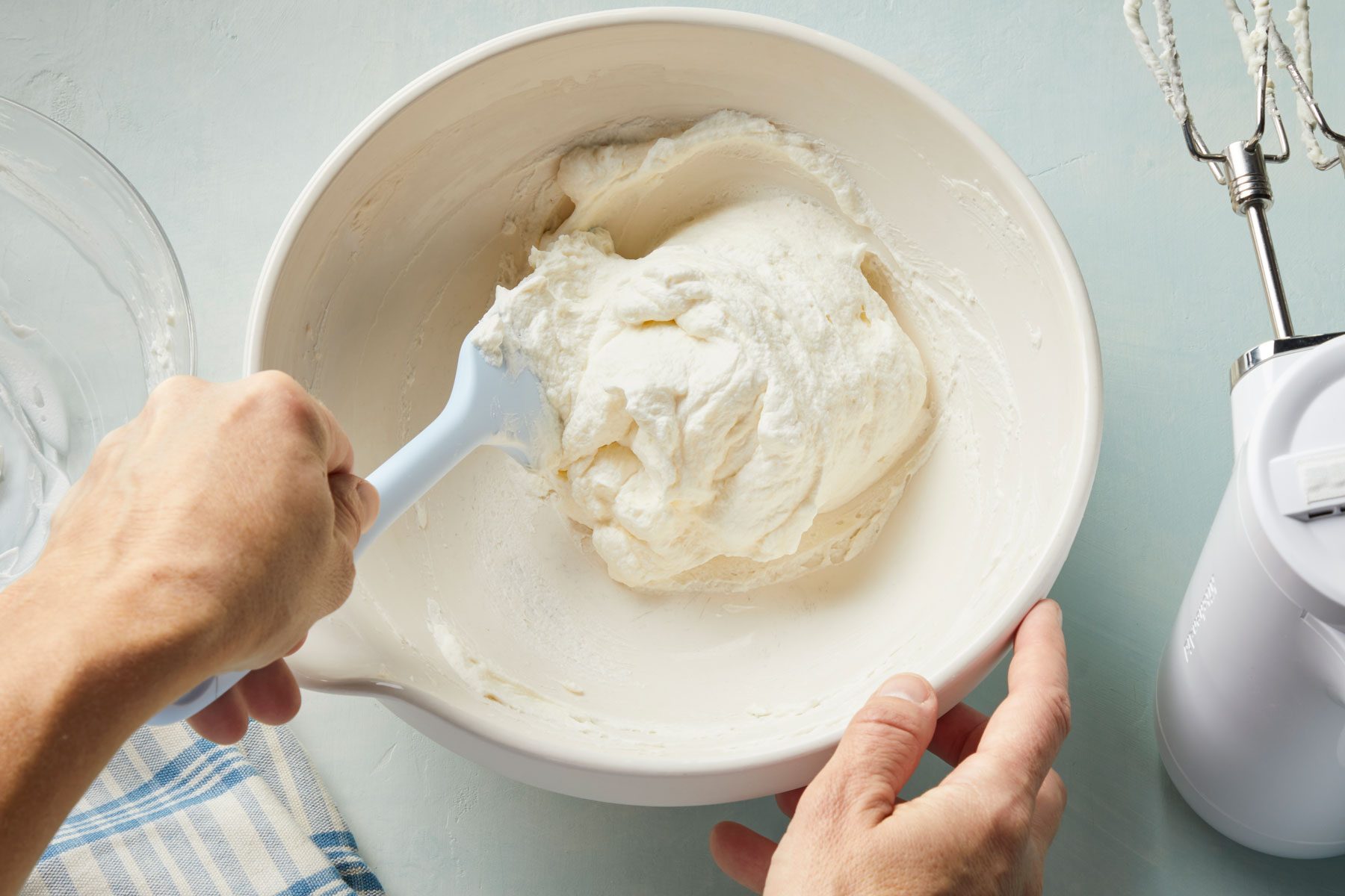 A person mixing cream in a bowl