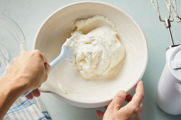 A person mixing cream in a bowl
