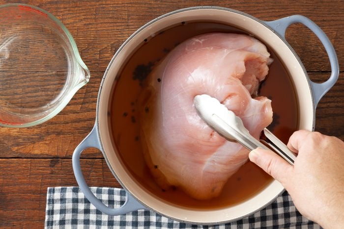 placcing turkey in pot with brine