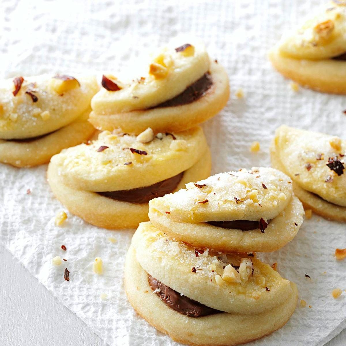 Folded hazelnut cookies dusted with hazelnuts and filled with nutella