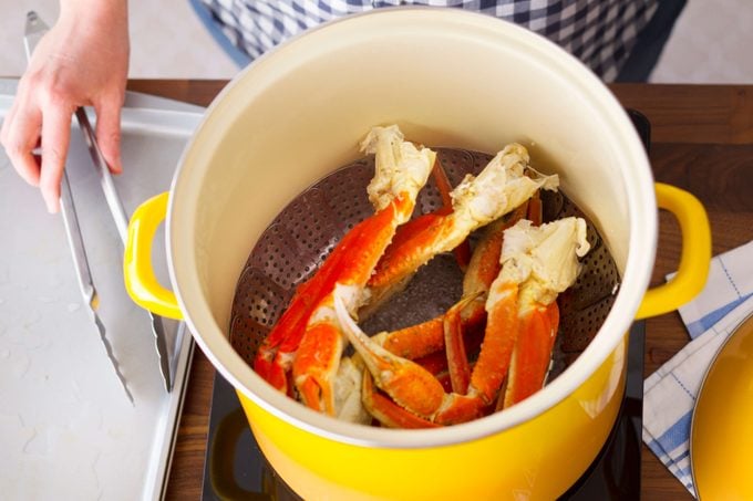 Steaming crab legs in a bright yellow pot