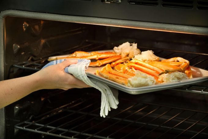 Crab legs on a baking sheet in an oven