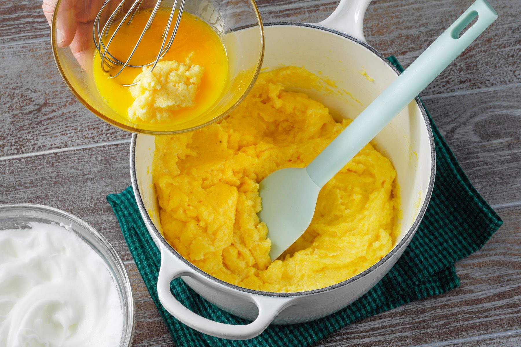 Mixing egg yolks in Cornmeal mixture in a large pan 