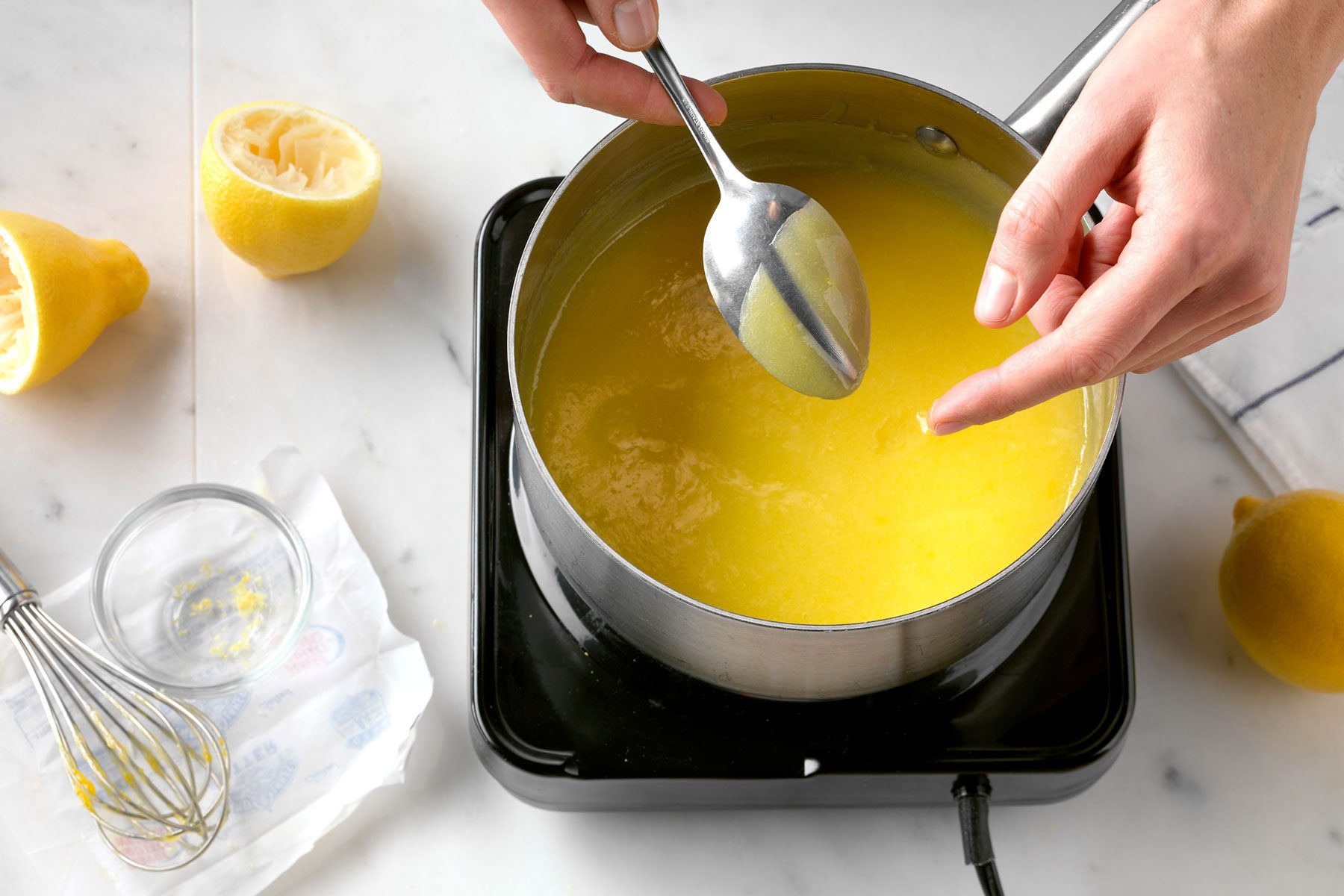 A Person Stirring a Lemon Curd Mixture in a Pot