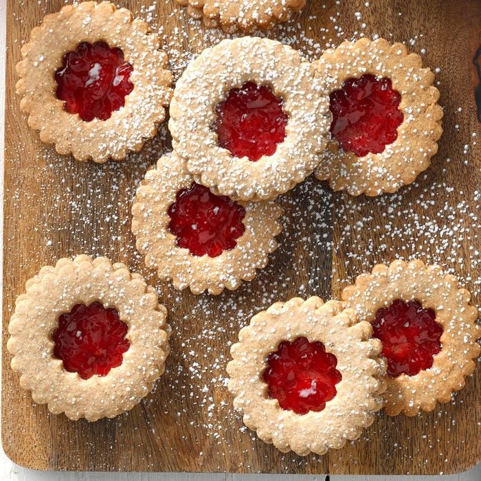 Linzer Cookies on a wood background with a berry filling