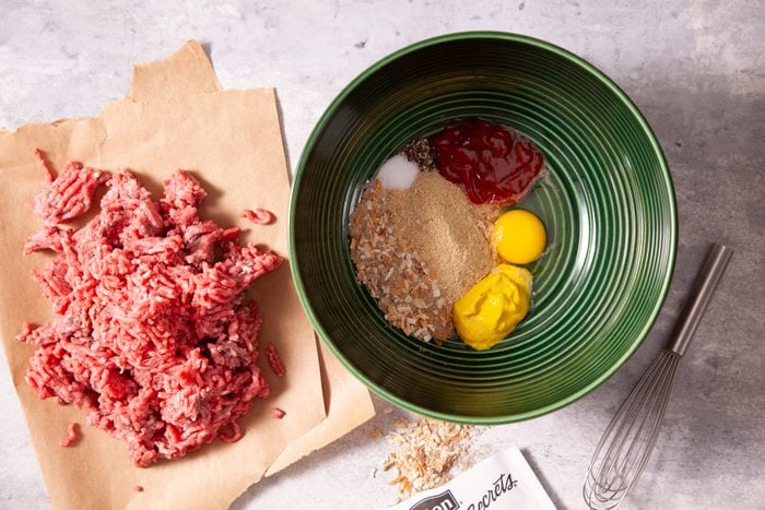 Ingredients for meat loaf in a bowl on a table.