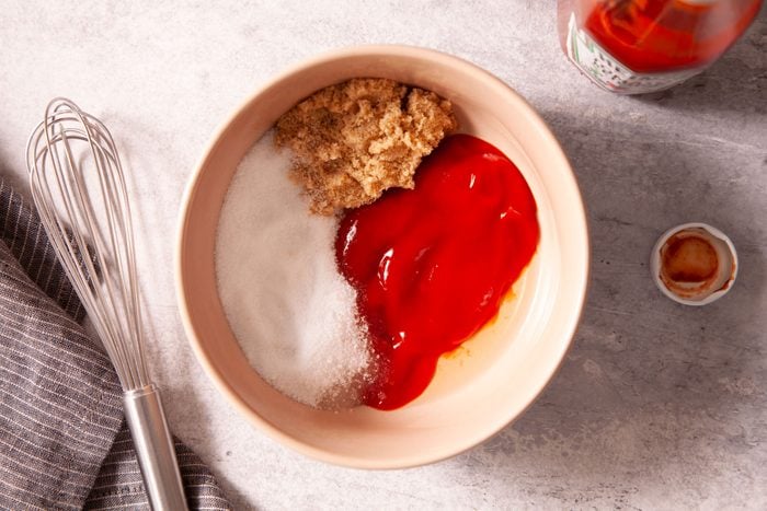 Ketchup and sugar in a bowl with a whisk
