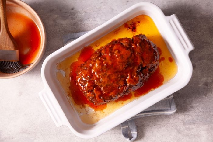 A Meat Loaf in a White Dish With Sauce