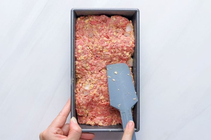 Pressing Meat Loaf Mixture into a Loaf Pan with the help of Spatula