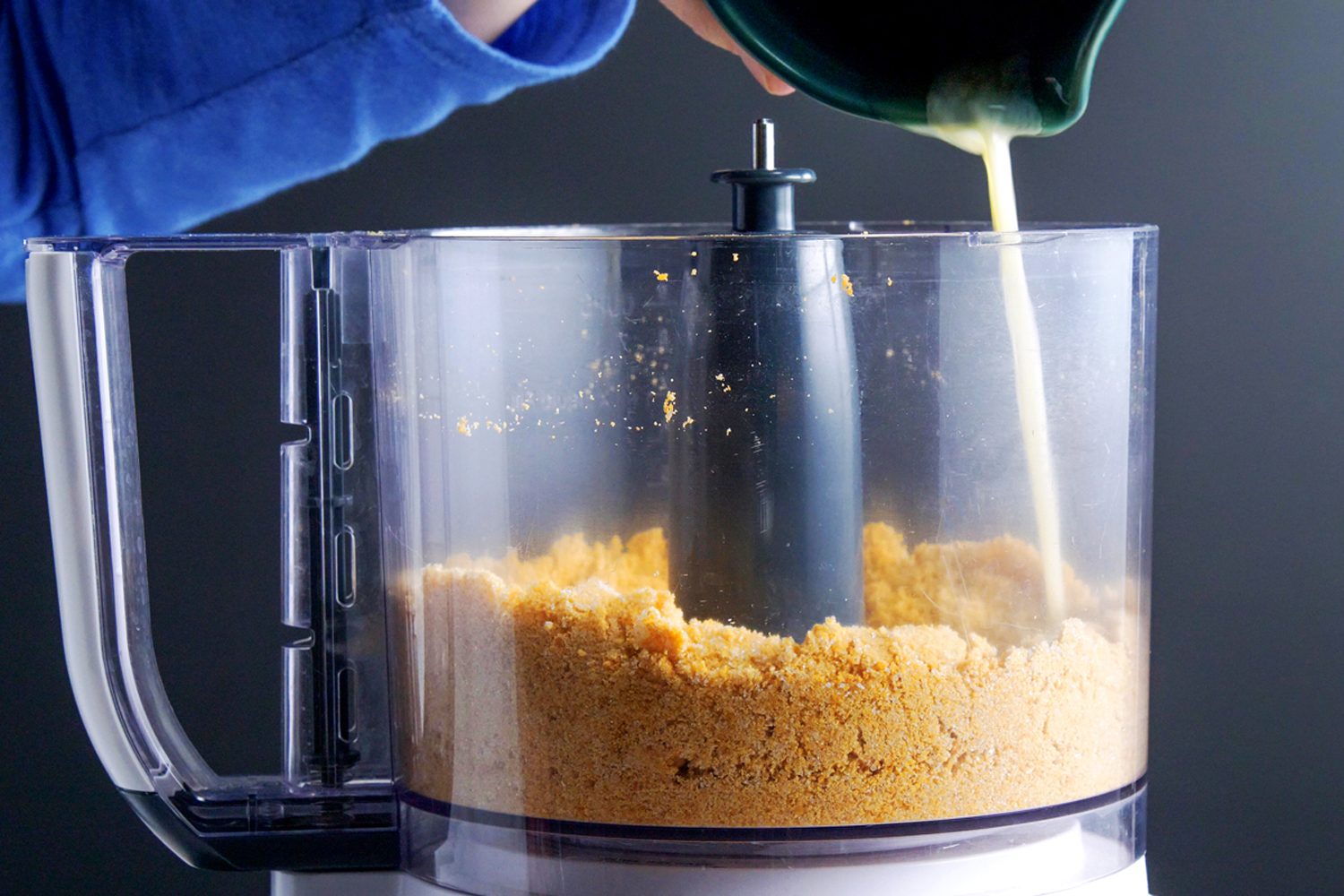 Melted butter being adder in the mixture of Cannoli shells in a food processor