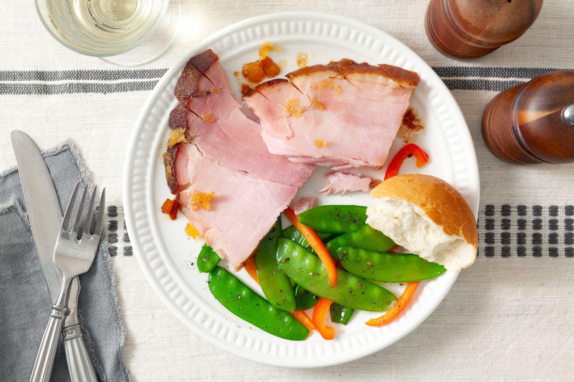 Pineapple Glazed Ham on a plate with green peas