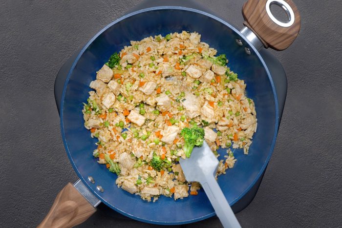 Fried rice in a wok with a wooden spoon