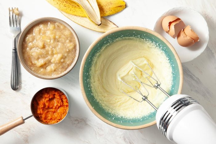A Bowl of Ingredient Mixture With a Whisk and a Banana Peel