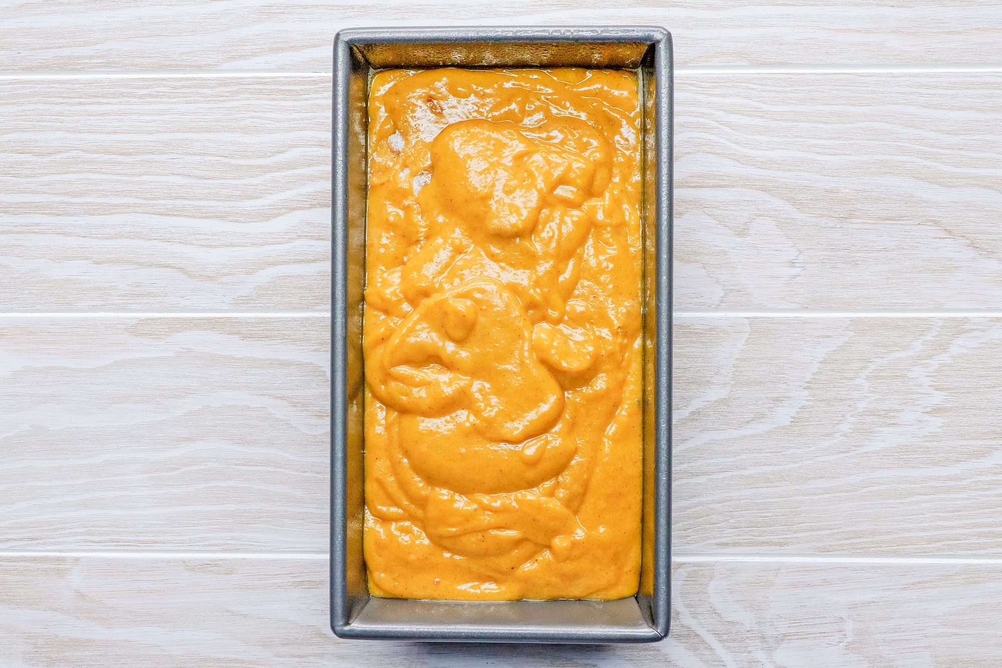 Pumpkin Bread Batter in a Loaf Pan Ready to Bake on Wooden Surface