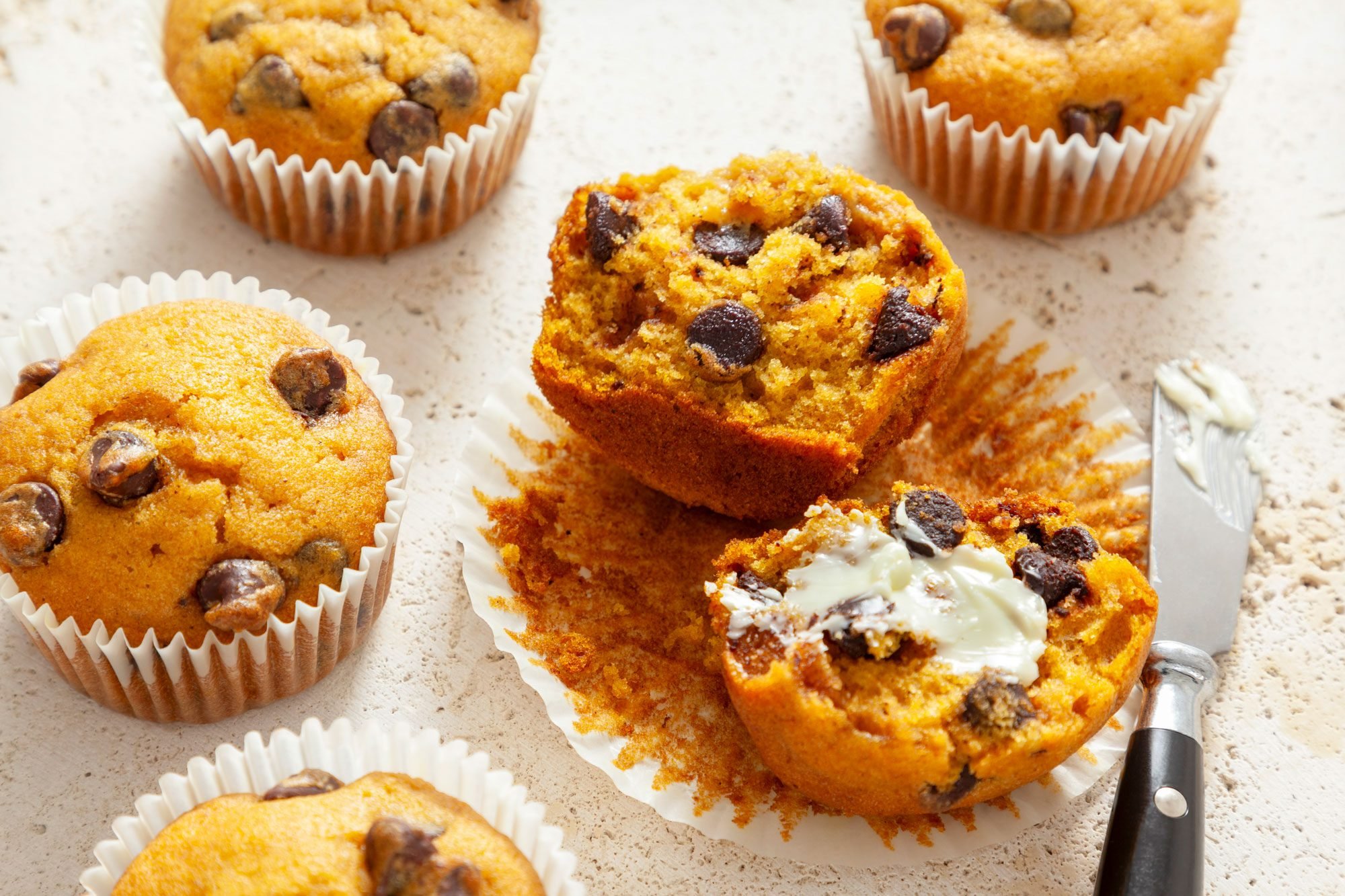 Pumpkin Chocolate Chip Muffins on Rough White Surface