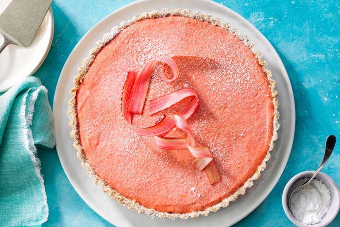 Rhubarb Tart With Shortbread Crust in a White Plate on Greenish Blue Background