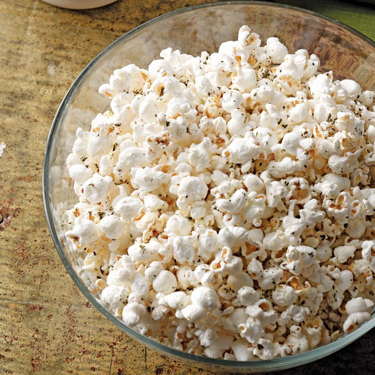 rosemary popcorn in a large glass bowl