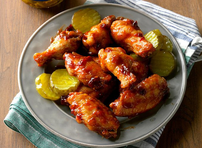 Spicy bbq buffalo wings next to pickle slices