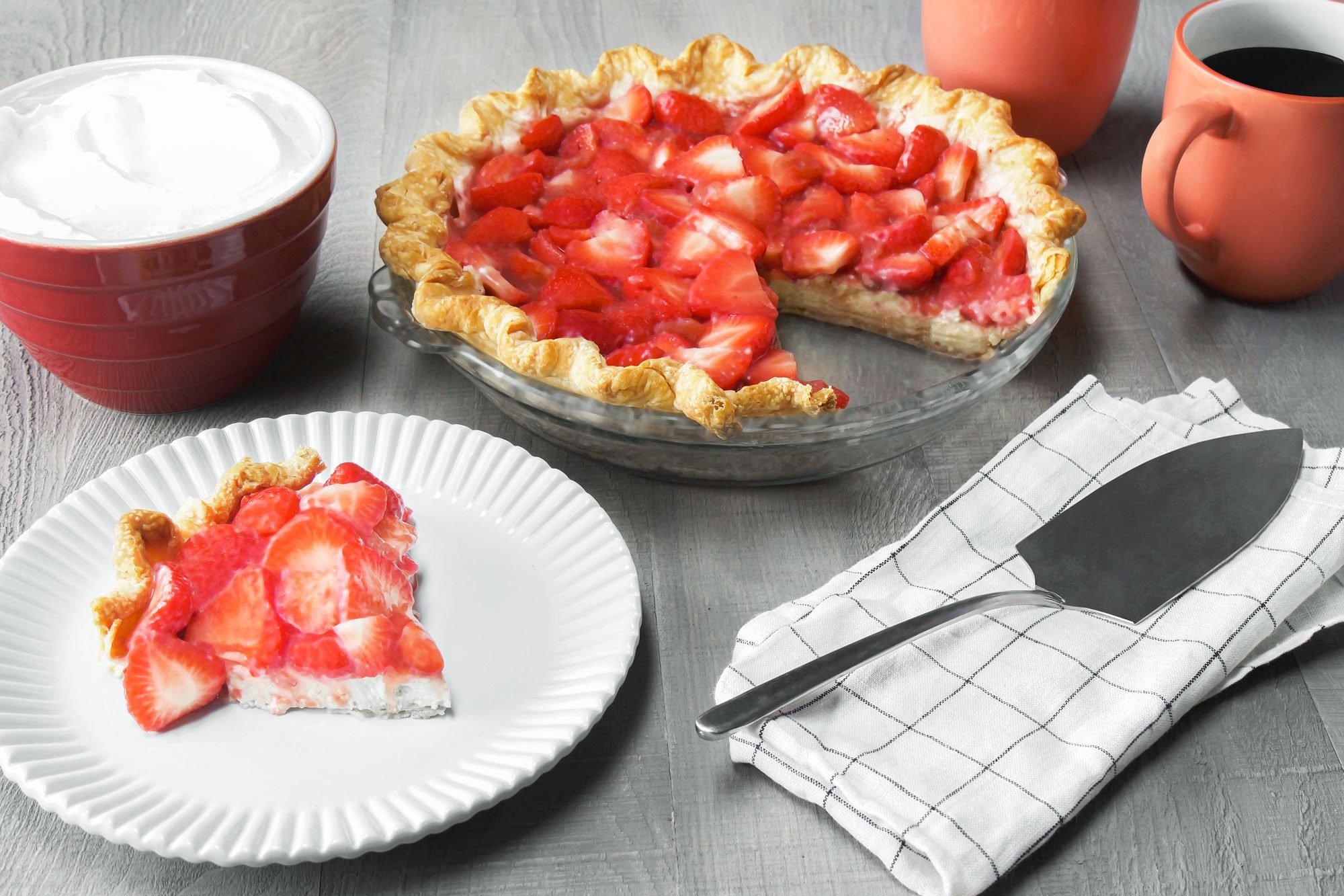 Strawberry Cream Cheese Pie sliced in a plate with whipped cream and coffee