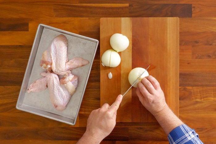 A Person Cutting an Onion With a Knife on a Cutting Board