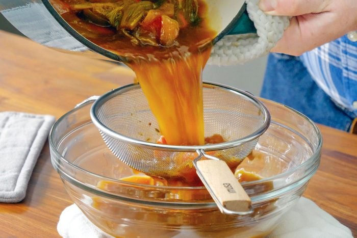 A Person Pouring Turkey Broth into a Bowl