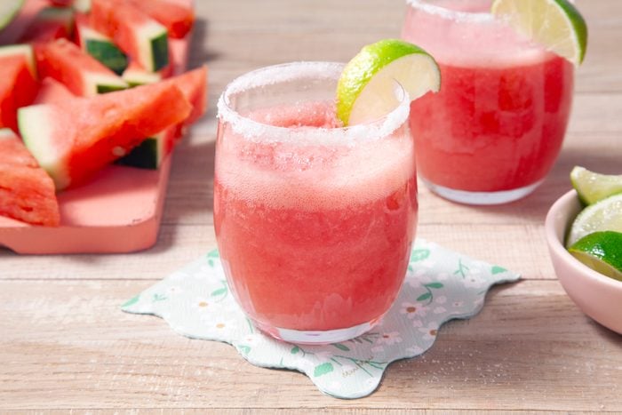 watermelon margaritas in rimmed glasses with lemon garnish
