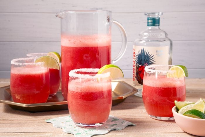 A pitcher of watermelon Margaritas with limes