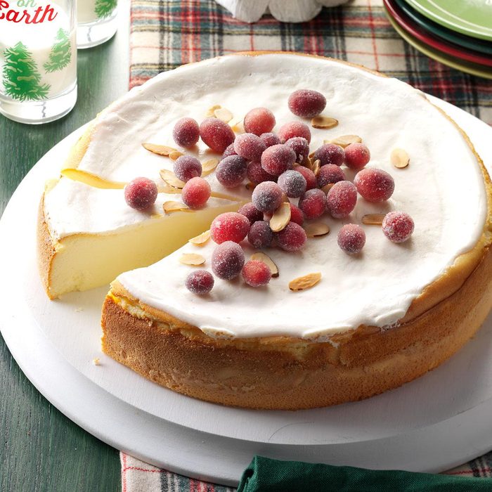 Amaretto Ricotta cheesecake topped with sugared cranberries and served to guests