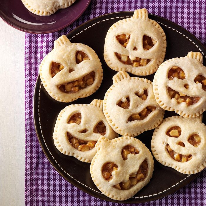 Mini pumpkin maple pies in the shape of jack-o-laterns arranged on a plate