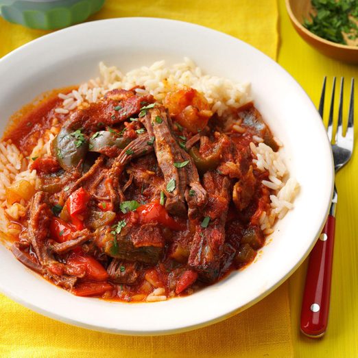 Cuban Ropa Vieja in a white bowl on a yellow tablecloth