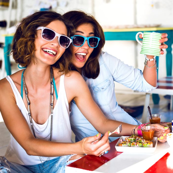 Two pretty best friend girls enjoy their lunch together in cute cafe, smiling speaking and gossip, bright clothes sunglasses, jewelry and accessorizes. portrait of women taking breakfast .; Shutterstock ID 287935583