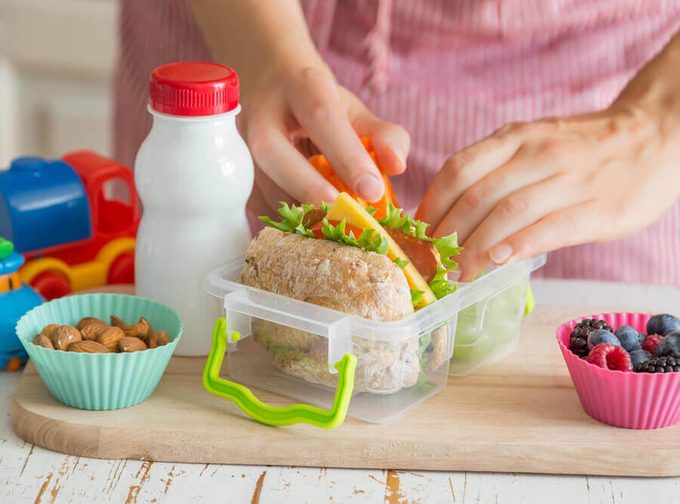 Mother making school lunch in the kitchen; cupcake liners