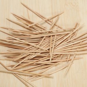 many wooden toothpicks on wooden table background