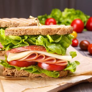 Delicious Ham, Salami, Cheese and Vegetables Sandwiches on Toasted Whole Grain Bread 