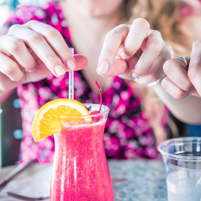 Closeup of two alcoholic summer drinks, strawberry daiquiri and pina colada, in restaurant with people's hands touching, taking straws; Shutterstock ID 783881164; Job (TFH, TOH, RD, BNB, CWM, CM): Taste of Home