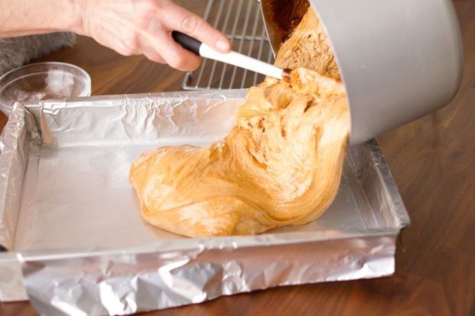 pouring sponge candy into a pan