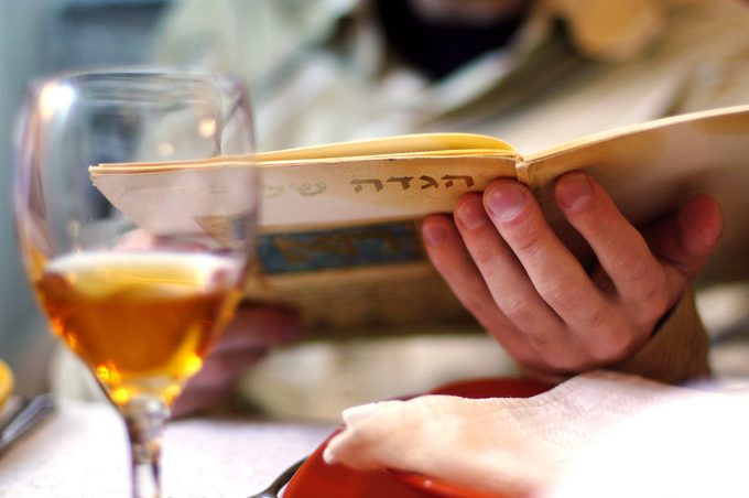 Man reads in the Haggadah book during Passover Seder dinner.