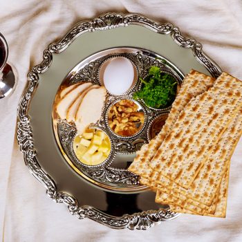 A Passover Seder plate, glass of wine and matzo for a Passover seder.