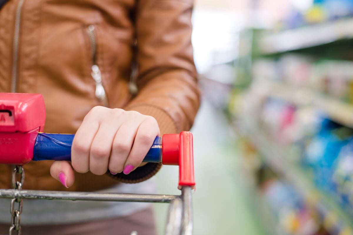 close up on hand of a woman on a supermarket trolley carries