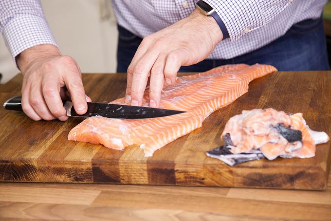 Preparing fish filet in kitchen