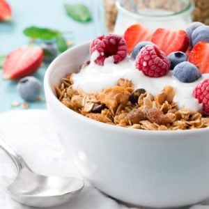 Granola in a bowl topped with yogurt and different berries